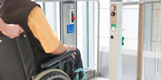 Rollstuhlfahrer vor einem Fahrstuhl